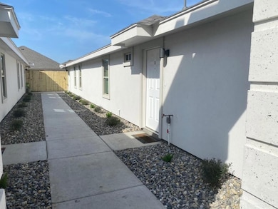 View of side of home with stucco siding and fence