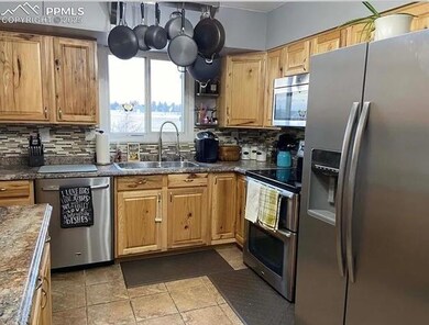 Kitchen with a sink, dark countertops, tasteful ba