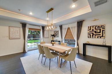 Dining room featuring a raised ceiling, recessed 