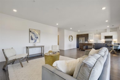 As you enter, the expansive floor plan beckons with laminate wood flooring, high ceilings, and large windows adorning the back wall, framing the bustling cityscape