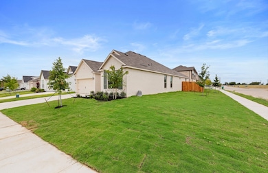 View of side of property featuring driveway, brick siding, and a garage