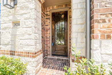 This gorgeous home instantly greets you with a stunning stained wood front door with gorgeous iron detailing.
