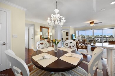 Dining space featuring dark wood finished floors, crown molding, a ceiling fan, and a chandelier