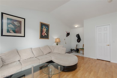 Living room featuring lofted ceiling and light woo
