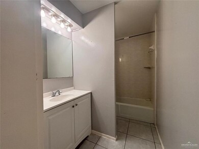 Bathroom with tile patterned floors, vanity, baseboards, and  shower combination