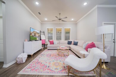 Living room featuring a ceiling fan, ornamental molding, recessed lighting, and dark wood finished floors