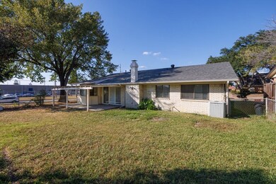 Back of house featuring a patio area, a chimney, and brick siding