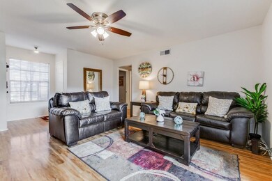 Living room with ceiling fan and light wood-style 