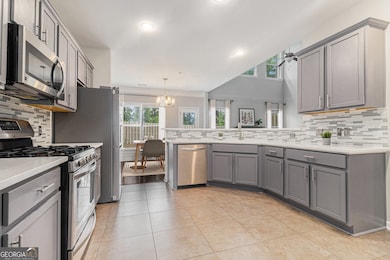 Renovated Kitchen showcases Quartz Countertops, Stainless Steel Appliances, Freshly Painted Gray Cabinets, a Breakfast Bar, and a Walk-In Pantry.