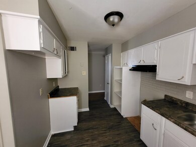 Kitchen featuring backsplash, sink, white cabinets, and dark hardwood / wood-style floors
