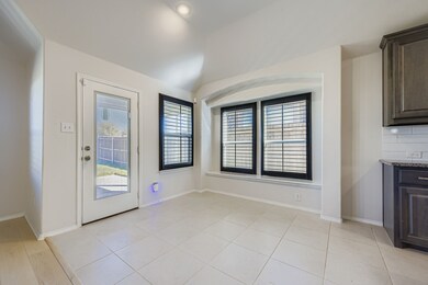 Unfurnished dining area featuring light tile patterned floors and vaulted ceiling