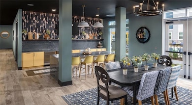 Dining room with wet bar, light wood finished floors, and a chandelier