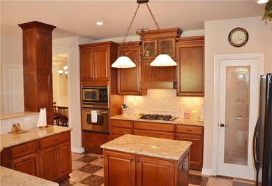 Spacious gourmet kitchen with island, under-cabinet and in-cabinet lighting, and large pantry.