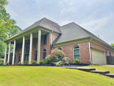 View of front of house with brick siding, a front lawn, and roof with shingles