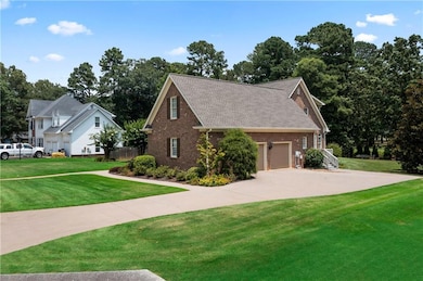 View of property exterior featuring brick siding, a yard, concrete driveway, an attached garage, and a shingled roof