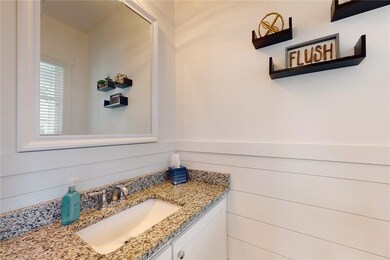 Half bath off the kitchen has custom shiplap.