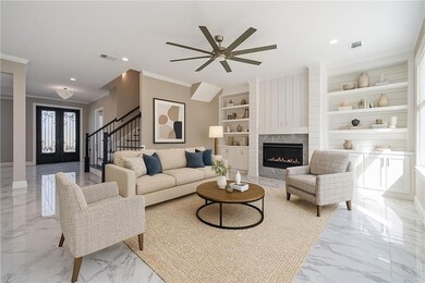 Living area with crown molding, built in features, ceiling fan, visible vents, and marble finish floor. Virtually Staged