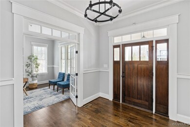 Foyer entrance with a chandelier, dark wood-type f
