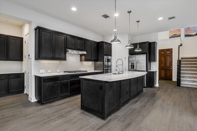 Kitchen with a sink, dark cabinetry, stainless st