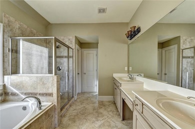 Bathroom featuring double vanity, a shower stall, 
