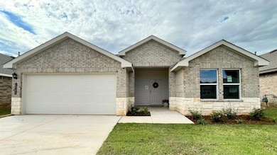 Ranch-style home featuring a garage, concrete driveway, stone siding, and a front yard