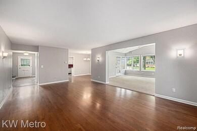 Unfurnished living room with dark wood finished floors and a chandelier