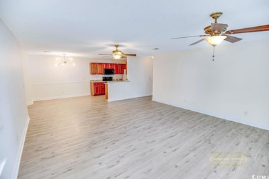 Unfurnished living room with light wood finished floors, ceiling fan, and a chandelier
