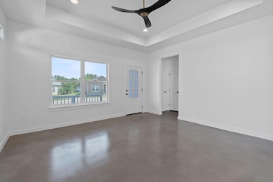 Spare room featuring a tray ceiling, finished con