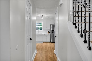 Hallway featuring fresh paint and view to kitchen