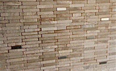 Attractive stone back splash with metallic tile in