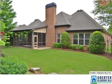 REAR ELEVATION SHOWING BRICK FIREPLACE AND LUSH LA