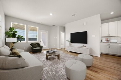 This bright and inviting living area offers an open layout with abundant natural light and a seamless flow to the kitchen. Featuring neutral tones, recessed lighting, and luxury vinyl plank flooring, this space combines comfort and modern style. The large windows and backyard access create the perfect setting for relaxing or entertaining.