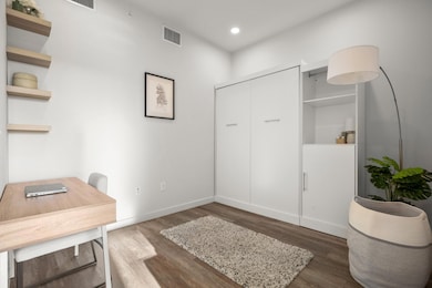 Office space with dark wood-type flooring and rec