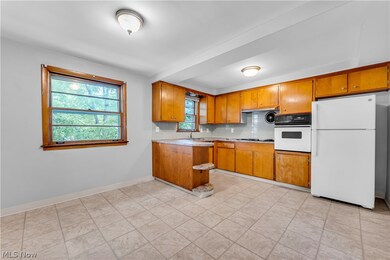 Kitchen with backsplash, sink, white appliances, and light tile patterned floors