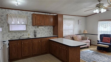 Kitchen featuring crown molding, a textured ceiling, open floor plan, white electric range, and ceiling fan