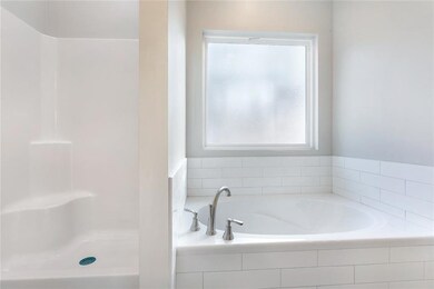 Garden tub designed with large subway tile, along