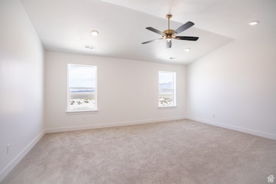 Spacious primary bedroom with vaulted ceiling and ceiling fan.