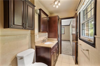 Bathroom with vanity, tile patterned floors, and tile walls