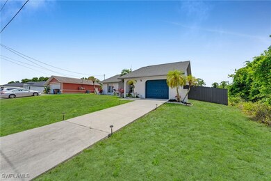 View of front of house featuring driveway, fence,