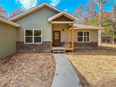 View of front facade with stone siding and a porch