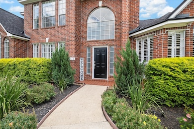 A striking front door offers a warm welcome with t
