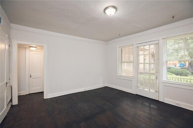 Empty room featuring dark wood-type flooring and baseboards