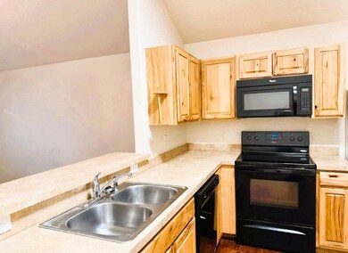 Kitchen featuring a sink, light countertops, blac
