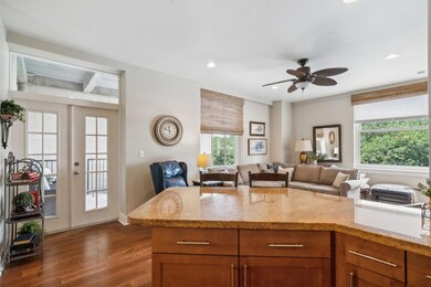 Kitchen with light stone countertops, dark hardwoo