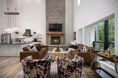 Living room with a towering ceiling, light hardwoo