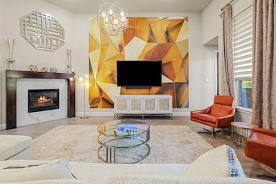 Living room featuring a high end fireplace, wood finished floors, and a chandelier