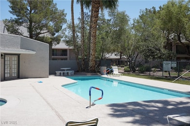 Community pool with french doors and a patio