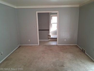 Empty room featuring light carpet and baseboards