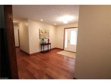 A large foyer with hard wood floors greets you as 