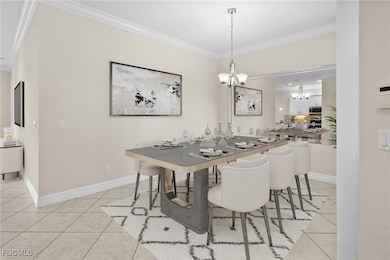 Dining area with crown molding, light tile patterned floors, and a chandelier